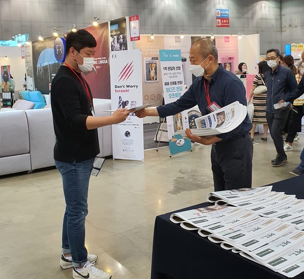 김성일 펫헬스 대표가 케이펫페어 일산에서 종이신문을 배포하고 있다 @펫헬스