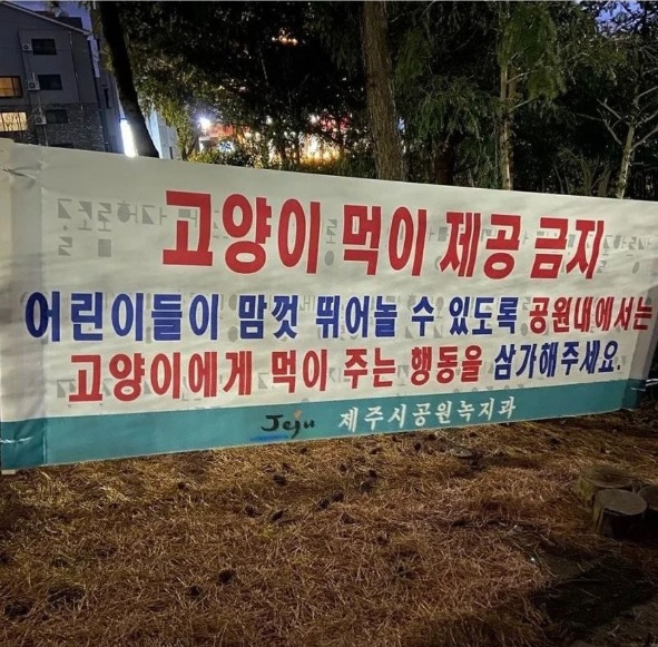 지난 13일 경 제주시가 관내 한 공원에 설치한 ‘길고양이 급식 금지’ 현수막. 사진 벨아벨