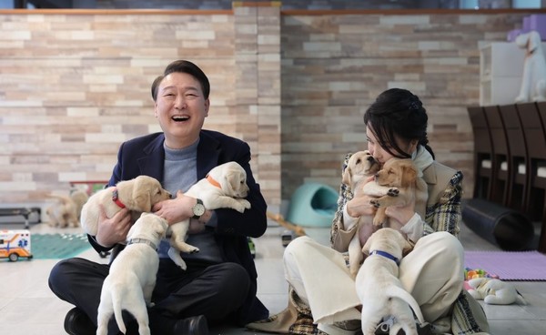 24일 은퇴 안내견 분양행사에 참석한 윤석열 대통령 부부가 강아지들을 안고 환하게 웃고 있다. 사진 대통령실